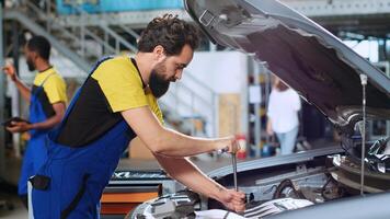 calificado militar en coche Servicio usos esfuerzo de torsión llave inglesa a apretar tornillos dentro vehículo después fijación componentes adentro. reparar tienda experto utilizando profesional herramientas a arreglar automóvil foto