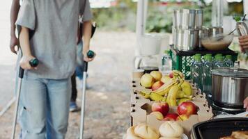 Multiracial volunteers provide hunger relief assistance to a caucasian woman on crutches and the less fortunate. Charity workers share free food and provisions to the homeless and disabled. photo