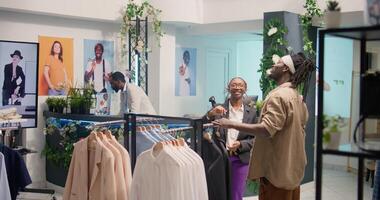 Retail assistant in shopping outlet using AR tech to showcase cheap and sustainable clothes to customer. Dolly in shot of employee in eco friendly second hand store using augmented reality hologram photo