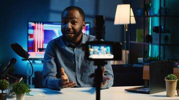 Close up shot of camera on tripod used by internet star in neon lit apartment studio to film video for online platforms. Professional recording equipment used by content creator to capture footage photo