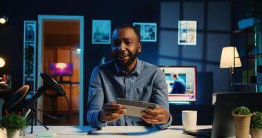 African american online star doing technology review of Bluetooth portable speaker for online platforms channel. BIPOC influencer unboxing music playing device for his audience photo