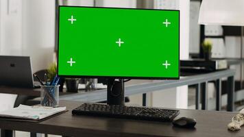 Workstation desk with greenscreen monitor in business agency office, empty coworking space with modern gadgets used for company operations. Computer showing chromakey and mockup template on display. photo