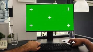 POV of young man at office desk checking greenscreen and isolated chromakey template, solving business operations. Manager sitting at desk looking at blank mockup display. Tripod shot. photo