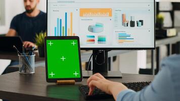 oficina gerente trabajando con pantalla verde en tableta, mirando a aislado Bosquejo diseño en dispositivo y refinamiento negocio operaciones en computadora. mujer de negocios análisis blanco espacio de copia. foto