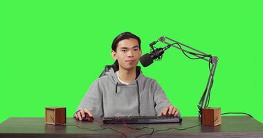 POV of vlogger broadcasting rpg gameplay over full body greenscreen in studio, content creator streaming live web contest. Asian video blogger playing games and broadcasting at desk. photo