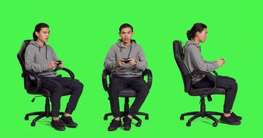 Young gamer playing videogames over full body greenscreen template, using joystick and enjoying competition with people online. Person having fun with rpg action contest on console. photo