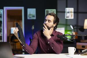 Influencer filming keyboard review in personal studio, thinking how to rate it. Tech guru showcasing computer peripheral to audience on niche online channel, giving it feedback photo