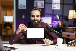 Portrait of smiling man in studio filming tech tutorial on how to do maintenance on mockup broken tablet. Online show host teaching subscribers how to open and fix isolated screen digital device photo