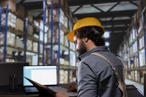 Distribution engineer works on transportation and logistics details with file documents and supply contracts. Warehouse employee managing stock production and distribution, industrial depot. photo