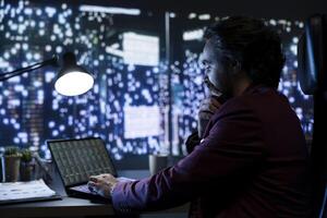 Economist investigates accounting records of enterprise to provide suggestions to the board about boosting financial stability and performance. Management expert gazing at city center lights. photo