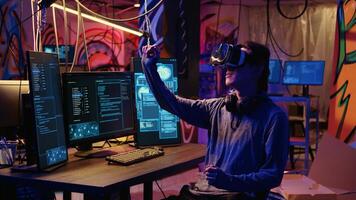 Hacker using virtual reality goggles technology to steal sensitive data by taking advantage of security breaches. Cybercriminal in hidden base using VR headset to gain unauthorized access to systems photo