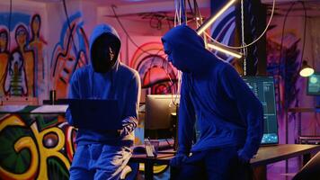 New member in hacking group receiving guidance from experienced rogue programmer acting as his mentor in underground hideout. Master hacker teaches script kiddie how to develop malware photo