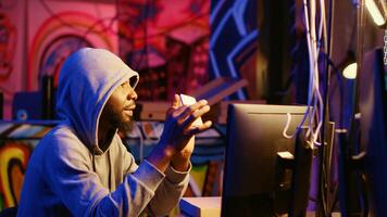 Hacker holding SSD device with valuable information after doing data breaches and financial theft. Cybercriminal with gathered users bank account credentials ready to sell it on black market photo