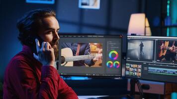 vídeo editor tomando teléfono llamada mientras pulido crudo imágenes, chateando con cliente acerca de oficial trabajar. camarógrafo negociaciones con cliente utilizando teléfono inteligente, que se discute necesario ajustes foto