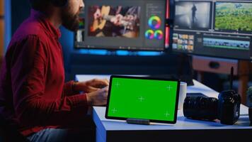 verde pantalla tableta en escritorio en multimedia agencia siguiente a vídeo editor trabajando para independiente producción empresa ingresando música, diálogos, gráficos y efectos terminado crudo imágenes foto