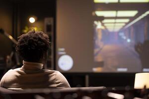 BIPOC man playing singleplayer videogames on widescreen TV, relaxing after long day at work. Gamer enjoying science fiction first person shooter game on gaming console, shooting enemies photo