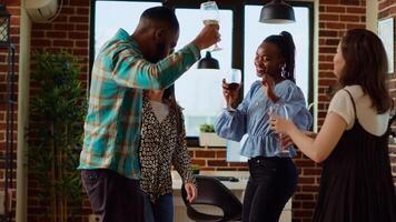 Smiling friends dancing at apartment party, entertaining themselves, feeling the rhythm. Mates doing energetic dance moves on animated songs in stylish living room during weekend photo