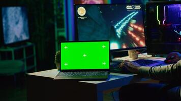 verde pantalla ordenador portátil siguiente a hombre teniendo divertido por utilizando juego de azar teclado a mosca astronave en sf videojuego. Bosquejo cuaderno y jugador utilizando poderoso ordenador personal y computadora periféricos a jugar juego foto