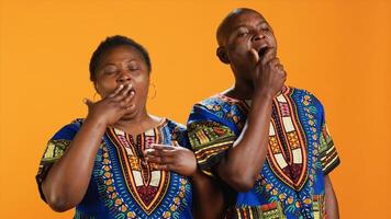 Sleepy african american people yawning in front of camera, feeling extremely tired over orange background. Man and woman being exhausted and dealing with burnout, overworked persons. photo