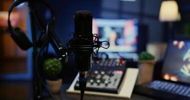 Panning shot of high tech mic used to produce quality online show for livestreaming channel. Professional streaming sound capturing and recording podcasting gear in empty apartment, close up photo