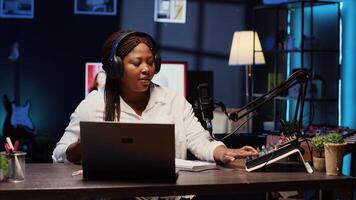 Woman arriving in studio, broadcasting live on streaming platform using professional tools producing high quality audio. Influencer putting headphones on, creating engaging social media content photo