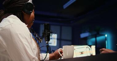 Woman laughing and enjoying cup of coffee during comedy focused podcast, entertained by funny man. Guest amused by talking show host telling jokes to her and audience watching at home photo