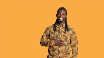 Confident male model laughing at jokes on camera, feeling happy and enjoying good times in studio. African american man acting silly and amusing over memes, having fun with laughs. photo