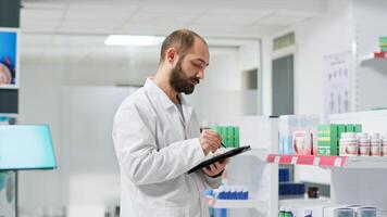 Healthcare workers monitoring pharmaceutical packs on racks and managing store inventory to guarantee clients are provided with goods. Pharmacy technician handling pills boxes logistics. photo