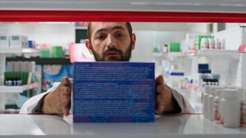 pov de Al por menor trabajador arreglando farmacia productos en estantes, poniendo valores en monitor para clientela a encontrar ninguna medicamento. farmacéutico trabajando en organizando medicamentos en farmacia. trípode disparo. foto