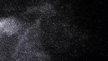 Abstract animation of small white particles exploding isolated on black background. Animation. White dry inks dust flying into the sides in the dark. photo