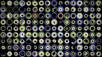 Plenty of small multicolored circles spinning on the black background in different sequence. Animation. Beautiful abstract background. photo