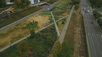 Top view of people walking in park alley in city. Clip. People walk and relax in modern city park. Landscape of city park alley with solar panels photo