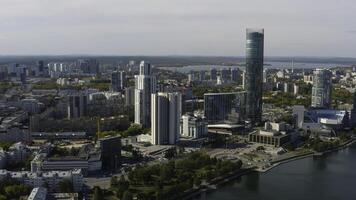 Top view of modern city with river on sunny summer day. Stock footage. High-rise buildings with modern glass buildings of modern city on river. Beautiful modern city with high-rise buildings and river photo