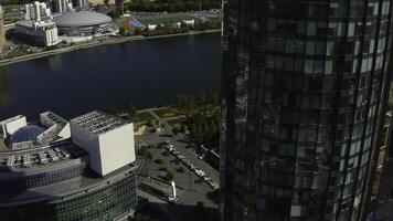 Top view of beautiful business skyscrapers by river. Stock footage. High-rise offices in business center of modern city in summer. Beautiful architecture and landscapes on riverbank in modern city photo