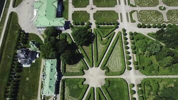 Top view of royal garden with patterns and ancient buildings. Creative. Amazing beauty of garden pattern and trails of royal palace. Territory of old rich estate with garden on sunny summer day photo