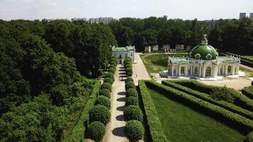 Top view of people walking on territory of palace garden. Creative. Beautiful road of palace garden with beautiful bushes and trees. Old building of royal estate with garden on sunny summer day photo