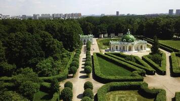 Top view of people walking on territory of palace garden. Creative. Beautiful road of palace garden with beautiful bushes and trees. Old building of royal estate with garden on sunny summer day photo