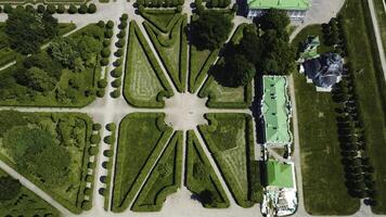 Top view of royal garden with patterns and ancient buildings. Creative. Amazing beauty of garden pattern and trails of royal palace. Territory of old rich estate with garden on sunny summer day photo