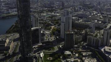 Top view of construction of building in city center with high-rise buildings. Stock footage. Landscape of city with high-rise buildings and building under construction in center. Beautiful summer photo