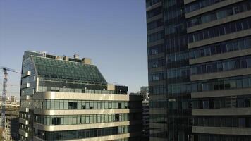 Top view of facade of beautiful glass skyscrapers. Stock footage. Beautiful glass skyscrapers in sunny summer day. Beautiful architecture of glass skyscrapers in center of modern city photo