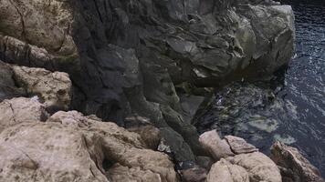 ver de peligroso Roca acantilados cerca mar agua. acortar. en borde de vertiginoso acantilados por mar agua. hermosa y peligroso agudo rocas con mar agua foto