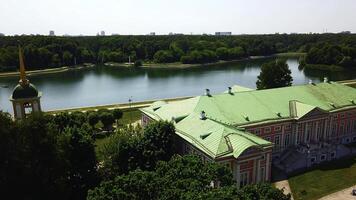 Top view of historic building by river with forest. Creative. Beautiful historical suburb with tourists on riverbank. Picturesque estate on river bank with forest on sunny summer day photo