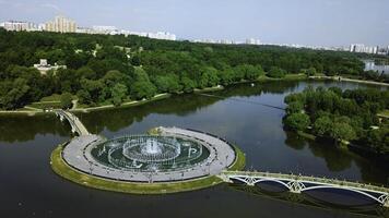 Top view of bridges in city pond with fountains. Creative. Island with bridges and fountains in city pond. Beautiful fountain complex on river island with pedestrian bridges photo
