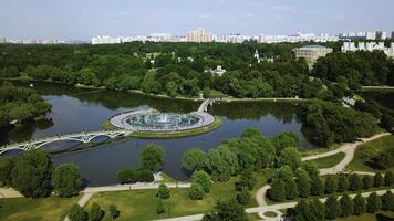 Top view of bridges in city pond with fountains. Creative. Island with bridges and fountains in city pond. Beautiful fountain complex on river island with pedestrian bridges photo