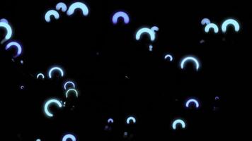 Neon rings move and vibrate in space. Design. Small neon rings vibrate in dark space. Luminous rings move in space with waves and reflection photo