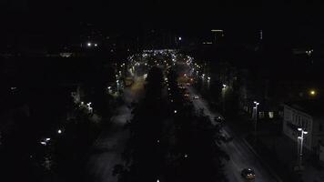 Top view of dark city at night with glowing lanterns. Stock footage. Beautiful view of highway with cars and lanterns. Night road in the center of modern city with lanterns photo