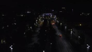 Top view of dark city at night with glowing lanterns. Stock footage. Beautiful view of highway with cars and lanterns. Night road in the center of modern city with lanterns photo