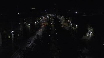 Top view of dark city at night with glowing lanterns. Stock footage. Beautiful view of highway with cars and lanterns. Night road in the center of modern city with lanterns photo