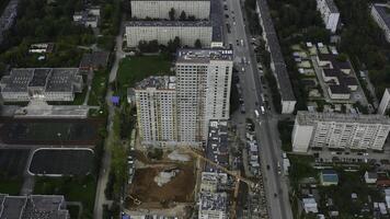 Top view of construction of multi-storey building in city. Stock footage. Construction of multi-storey building in city center on summer day. Panorama of modern city with construction of high-rise photo