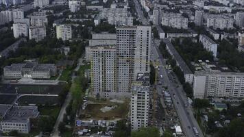 Top view of city with construction of high-rise building. Stock footage. Construction of multi-storey complex in residential area of modern city. Construction of high-rise building with crane on photo